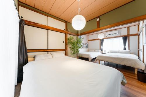 two beds in a room with wooden ceilings at SENJU Nakacho HOUSE , 千住仲町HOUSE in Tokyo