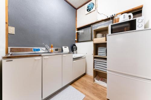 a kitchen with white cabinets and a sink at SENJU Nakacho HOUSE , 千住仲町HOUSE in Tokyo