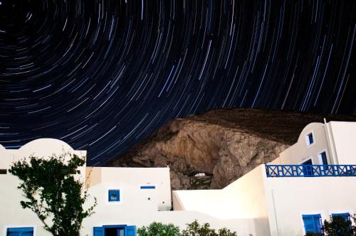 a starry night with stars in the sky over buildings at Irigeneia Hotel in Perissa