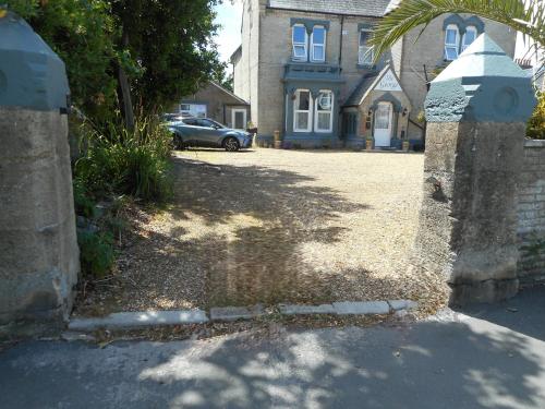 a house with a car parked in front of a driveway at The George B & B in Weymouth