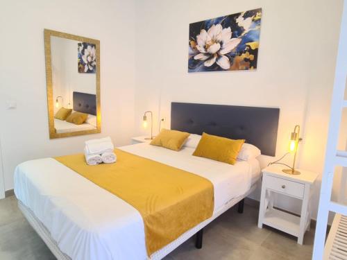 a bedroom with two beds and a mirror at Pensión Riosol in Seville