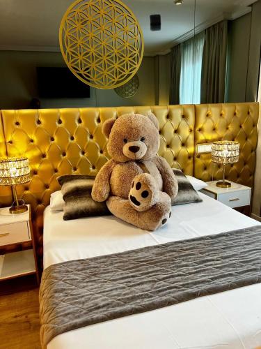 a large teddy bear sitting on top of a bed at Hotel Suites Feria de Madrid in Madrid