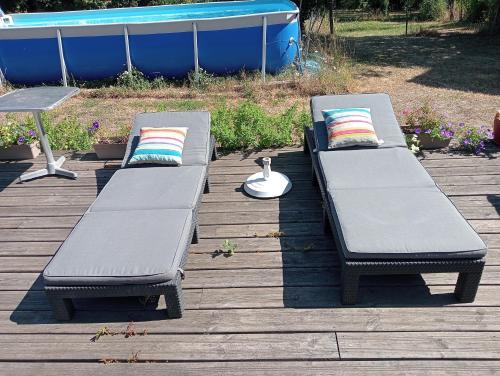 two benches sitting on top of a wooden deck at LES ROCHES DE COIGNE in Sainte-Anne-sur-Vilaine