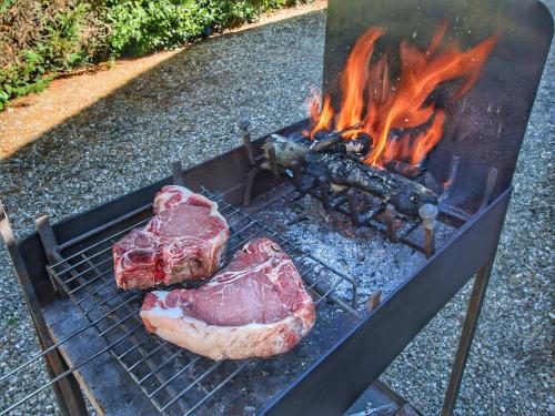 a piece of meat is cooking on a grill at Apartment in Tuscany near Lake Trasimeno in Valiano