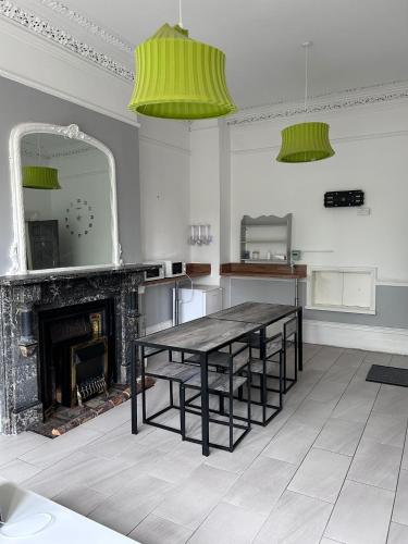 a dining room with a table and a fireplace at Triple room Private Bath Near LFC Free Street Parking No Breakfast in Liverpool
