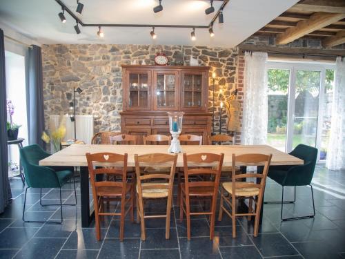 a dining room with a large wooden table and chairs at Tranquil Stay in Ardennes in Doische