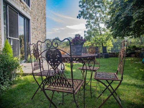 a wrought iron table and chairs in a yard at Tranquil Stay in Ardennes in Doische