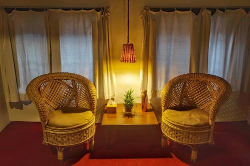 two wicker chairs and a table in a living room at Traditional Newari Homestay in Pātan