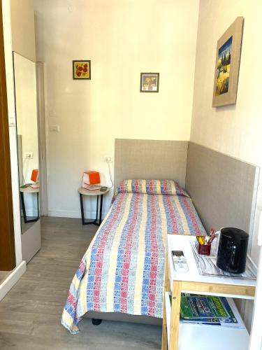 a small bedroom with a bed and a table at Hotel Alpino in Malcesine