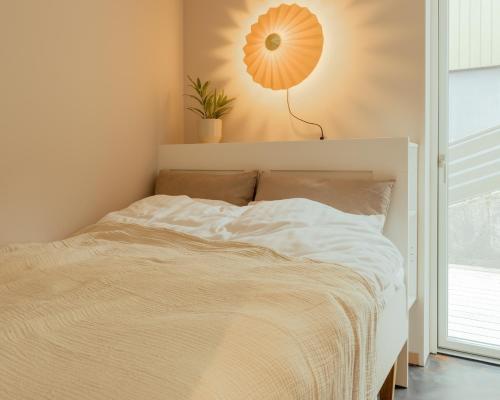 a bedroom with a bed with a plant on the wall at Hotel Vík - 3 BR Wellness Townhouses with Sauna, Jacuzzi & Panoramic Views in Haldarsvík