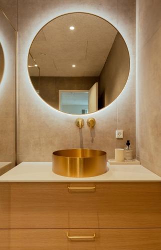 a bathroom with a sink with a large mirror at Hotel Vík - 3 BR Wellness Townhouses with Sauna, Jacuzzi & Panoramic Views in Haldarsvík