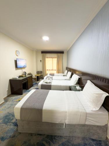 Habitación de hotel con 4 camas y TV en فندق سبال بلس - Sebal plus hotel, en Medina