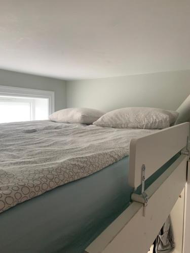 a bedroom with a large bed with a white mattress at Nice cozy appartment 15 m2 in The city center in Oslo