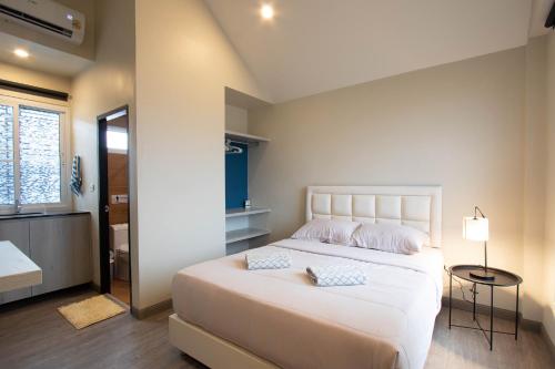 a bedroom with a large white bed with two pillows at บ้านอิ่มสุข in Ban Bua Phut