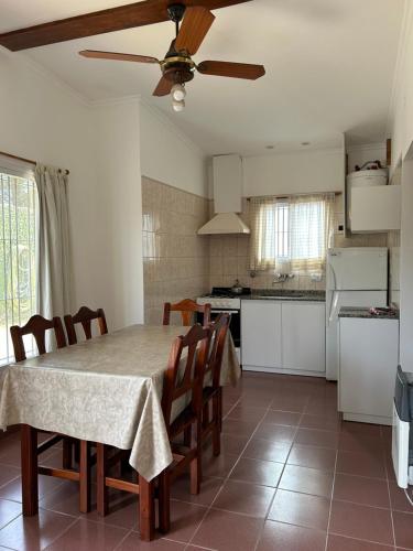 a kitchen with a table with chairs and a ceiling fan at Bungalows Familys in Concepción del Uruguay