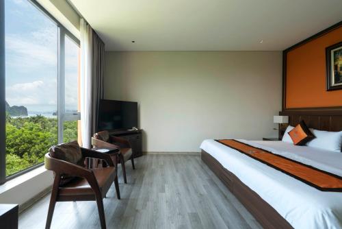a hotel room with a bed and a large window at Ruby Hotel Van Don in Tài Xá
