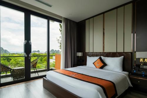 a bedroom with a large bed and a large window at Ruby Hotel Van Don in Tài Xá