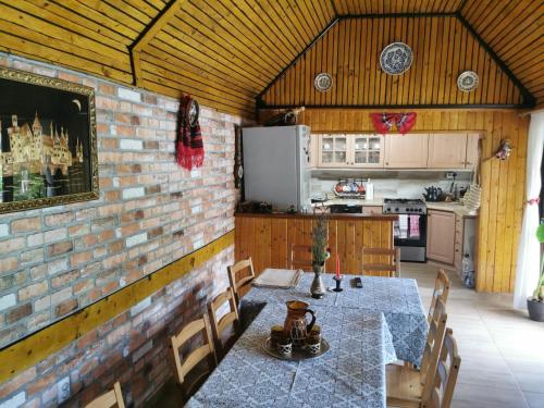 a dining room with a table and a kitchen at Casa de vacanta 1001 De Nopti in Corbşori