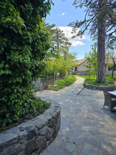 a stone path with a stone wall and a bench at Jubilee Hotel Troodos in Troodos