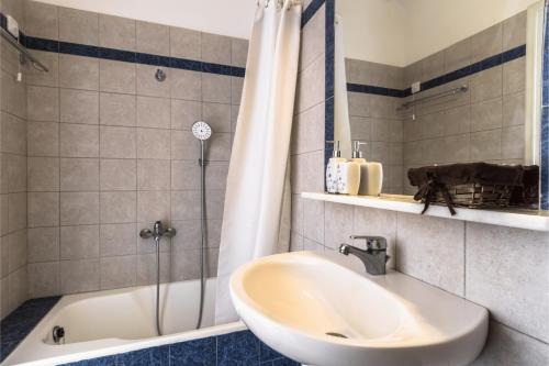 a bathroom with a tub and a sink and a shower at Irigeneia Hotel in Perissa