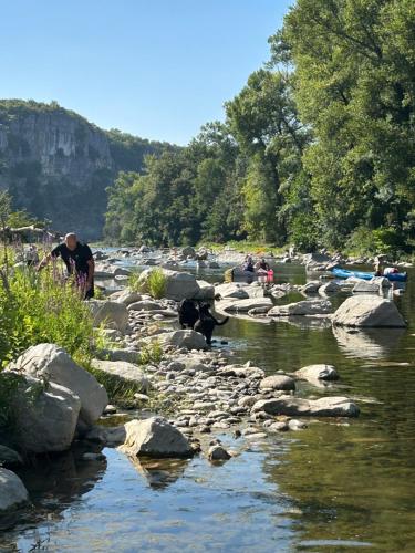 a group of people standing on rocks in a river at Emplacement tente, caravane 120 m2, Camping Beaussement in Chauzon