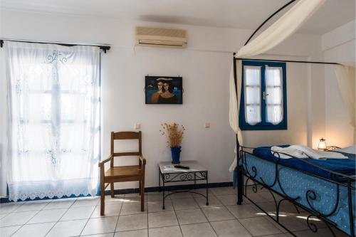 a bedroom with a bed and a chair and a table at Irigeneia Hotel in Perissa