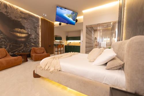 a bedroom with a large bed and a tv on the wall at Sea Suites - סוויטות מהממות עם מרפסת ליד המרינה באשקלון in Ashqelon