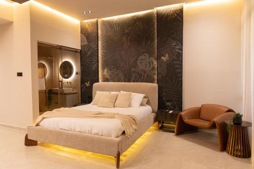 a bedroom with a bed and a chair at Sea Suites - סוויטות מהממות עם מרפסת ליד המרינה באשקלון in Ashqelon