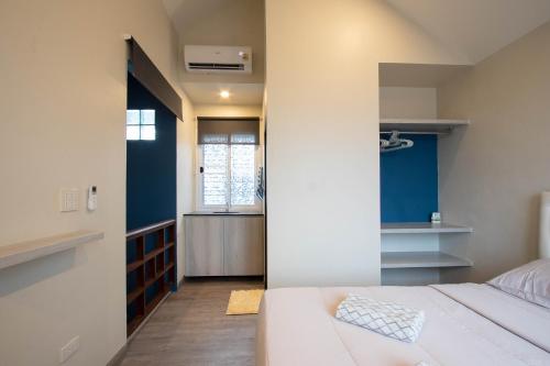 a bedroom with a white bed and a window at บ้านอิ่มสุข in Ban Bua Phut