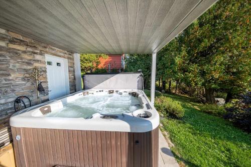a hot tub sitting under a canopy in a yard at SPA and Lake - Chalet le Relaxarium in Sainte-Germaine-du-Lac-Etchemin