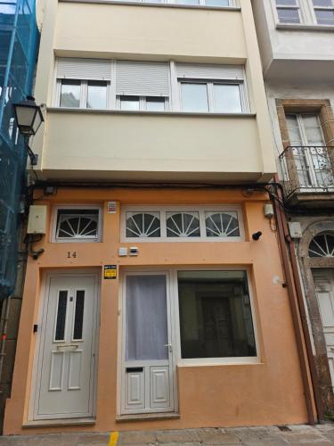 an orange building with a door and windows at O Camiño in Ferrol