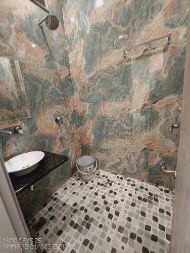 a bathroom with a sink and a tiled wall at Hotel Divaa Inn in Mathura