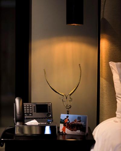 a telephone on a table next to a bed at Mantis Akagera Game Lodge in Akagera