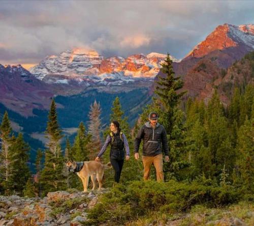 a man and a woman walking a dog on a mountain at Renovated 2 BR Aspen Condo Ski-in out in Aspen
