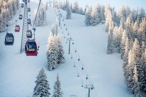 a group of ski lift cars on a snow covered slope at Renovated 2 BR Aspen Condo Ski-in out in Aspen