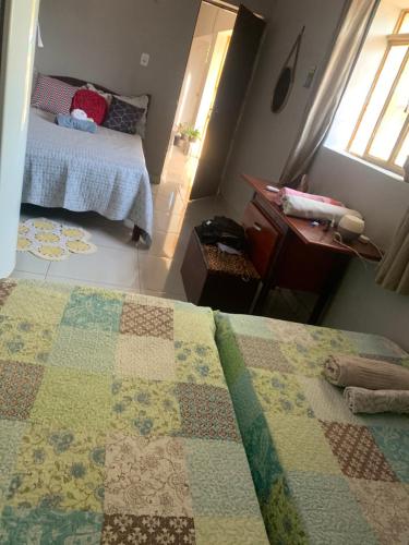 a bedroom with a bed with a quilt on it at Refúgio aconchegante no coração da cidade in Carolina