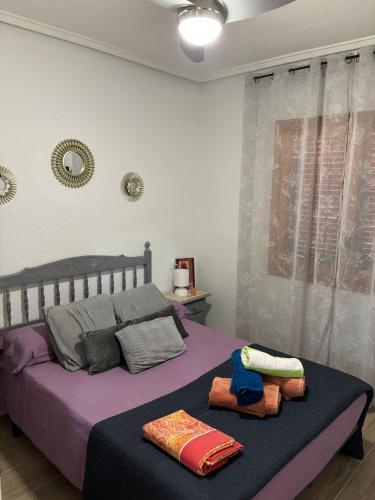 Un dormitorio con una cama con sábanas y almohadas púrpuras. en Apartamento en la playa, en La Mata