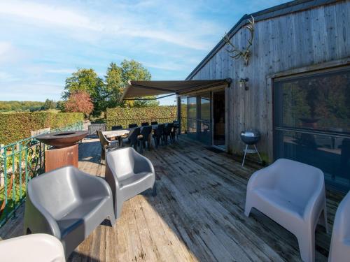 a deck with chairs and a table and a grill at Lush chalet near lake of Bütgenbach in Wirtzfeld