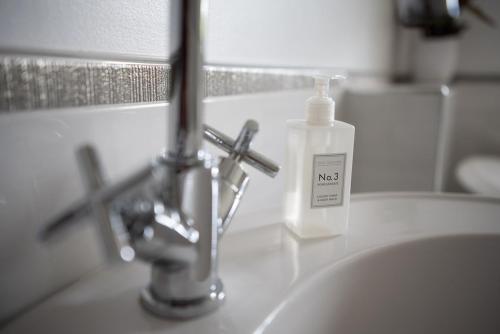 ein Waschbecken mit einer Seifenflasche drauf in der Unterkunft Large Country Home, Lake, Bar, Fire Hut, Sleeps 16 plus in Hillsborough