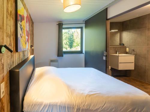 a bedroom with a large bed and a sink at Lush chalet near lake of Bütgenbach in Wirtzfeld