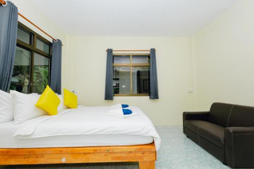 a bedroom with a bed and a couch at Charung by The Sea in Haad Rin