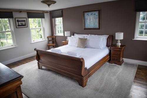 ein Schlafzimmer mit einem großen Bett mit weißen Laken und Kissen in der Unterkunft Large Country Home, Lake, Bar, Fire Hut, Sleeps 16 plus in Hillsborough