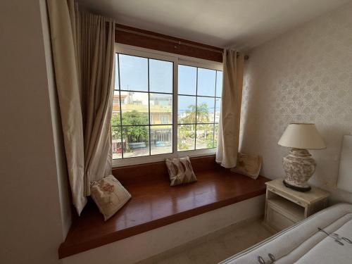 a window in a bedroom with a bed and a lamp at La Caleta Luxury Seaside Villa with 3 Bedrooms and Private Pool in Adeje