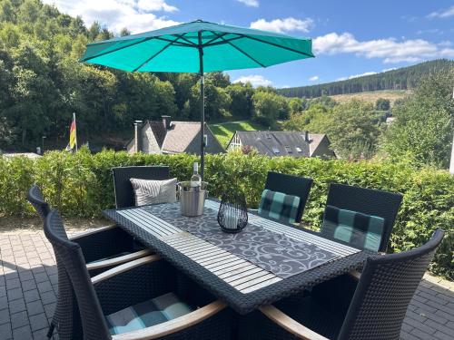 a table with an umbrella on a patio at Ferienwohnung "Apartment Sunlife Winterberg" 4 Sterne in Winterberg
