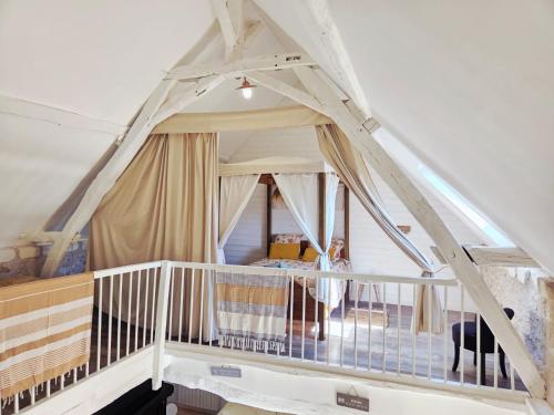 a room with an attic with a staircase and a bed at La Clef des Châteaux de la Loire, charme et zénitude in Azay-sur-Indre