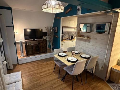 a dining room with a table and chairs and a kitchen at ''Le Nid Alpin'' Petit cocon avec vue sur les pistes de Métabief in Métabief
