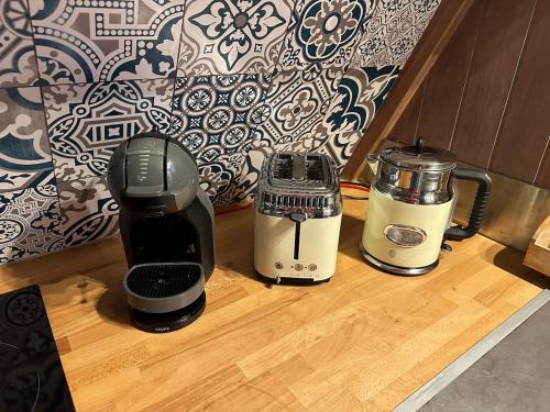 two coffee machines sitting on a wooden counter top at ''Le Nid Alpin'' Petit cocon avec vue sur les pistes de Métabief in Métabief