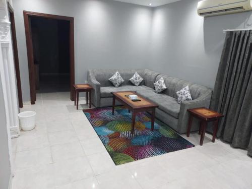 a living room with a couch and a table on a rug at تميز الحمدانية Tamayoz Al-Hamdaneyah in Jeddah