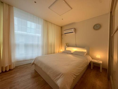 a bedroom with a large bed and a window at Healing stay just 3 minutes on foot from Gwanghwamun, within walking distance to Myeongdong, Gyeongbokgung, and Insadong in Seoul