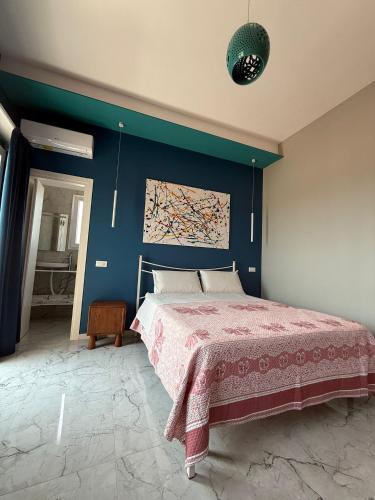 a bedroom with a bed and a blue wall at BeBaia in Leporano Marina